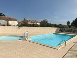 La BétaudièreÀ 150m de la plage的瓷砖庭院中的大型游泳池