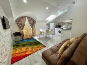 基希讷乌Premier City Apart Hotel Chisinau的客厅配有沙发和色彩缤纷的地毯