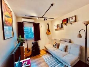 特拉维夫HIGH-END apartment , with a private parking and an elavator的客厅配有沙发和墙上的吉他