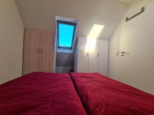 阿尔戈伊地区伊斯尼Ferienwohnung-Rotmoosblick-direkt-am-Rande-unberuehrter-Natur的一间卧室设有一张红色大床和窗户