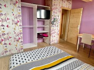 拉穆拉Chambre privée au pied des pistes - Chambre chez l'habitant - ChaletNelda com的一间拥有紫色墙壁的卧室和一张位于客房内的床