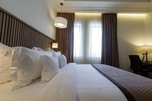 阿克拉D'avenue Boutique Hotel Accra的一张大白色床,位于酒店带窗户的房间内