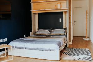 凡尔赛SweetHomeVersailles brand new flat 10mn walk from Palace的一间卧室配有一张大床和木制床头板