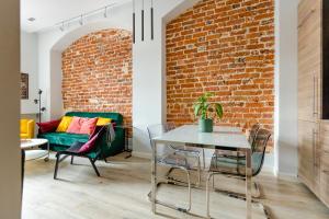 弗罗茨瓦夫Apartament Rynek的一间设有砖墙和桌椅的客厅
