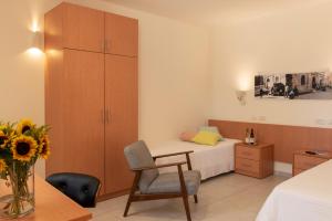 耶路撒冷Austrian Pilgrim Hospice的一间卧室配有一张床、一张桌子和一把椅子