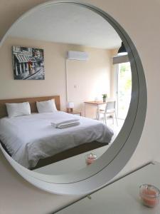 皮斯索里Pissouri Image的卧室配有白色的床和圆形镜子