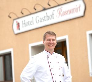 Au in der HallertauHotel Gasthof Rosenwirt的身穿厨师制服的人站在大楼前