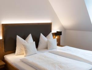 Au in der HallertauHotel Gasthof Rosenwirt的一张白色的大床,配有白色枕头