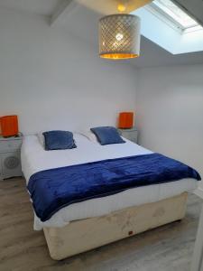 贝叶La Cour Royale的一间卧室配有一张带蓝色枕头的大床