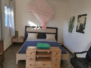 Acouala maison du nord的一间卧室配有一张带木桌的床