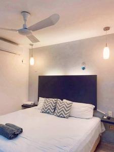 巴利亚多利德Casa Sol Y Luna Luxury Valladolid Yucatán的一间卧室配有一张白色大床和蓝色床头板