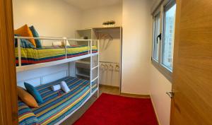 维戈Vigo centro ciudad, con garaje的一间设有两张双层床的客房,铺有红色地毯。