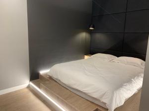 鲍里斯皮尔Apartment near the airport的一间卧室配有一张白色的床和黑色床头板