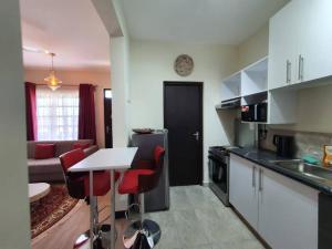 基利菲Elegant 1 Bedroom Condo Near Vipingo Ridge Golf Resort的一间厨房,里面配有桌子和红色椅子