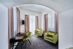 阿尔特廷Hotel Zur Post Altötting的酒店客房配有书桌、椅子和窗户。