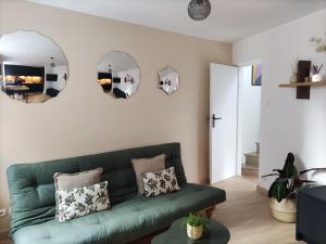 滨海图维列My Duplex House Trouville的客厅配有绿色沙发和两面镜子