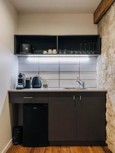 特赖厄班纳Triabunna Barracks的厨房配有黑色橱柜和水槽