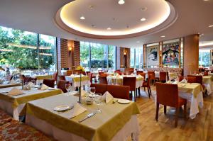 贝莱克Gloria Verde Resort - Kids Concept的餐厅设有白色的桌椅和窗户。
