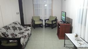 埃斯特角城Casa chalet en Solanas Portezuelo Punta ballena的配有床和两把椅子及一台电视的房间
