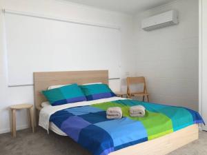 Ross RiverAiry Home - 3 Bedrooms & Office的一间卧室配有一张色彩缤纷的床和毛巾