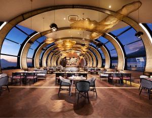 巴图巴图金郁金香荷兰度假村的餐厅设有桌椅和大窗户。