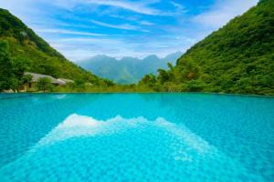 枚州县Mai Chau Mountain View Resort的蓝色的海水,背景是群山