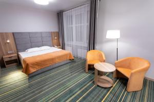 车里雅宾斯克公园城酒店的酒店客房,配有一张床和两把椅子