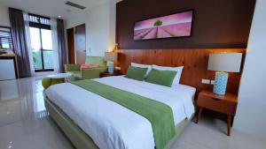 罗东镇川岸空中Villa的一间卧室配有一张带绿色和白色床单的大床