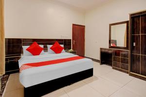 海米斯穆谢特أويو 590 ديالا للوحدات السكنية的一间卧室配有一张带红色枕头的大床