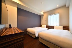 福冈WBF博多大酒店的酒店客房设有两张床和电视。