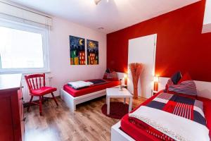 雷根斯堡Schalkhaus Regensburg的红色卧室配有床和椅子