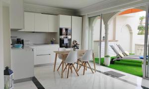 拉克鲁斯Luxury apartment, comfort and relax, views of the pool的厨房配有白色橱柜和桌椅