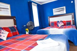 霍利盖特威克城堡住宿加早餐旅馆的蓝色卧室配有两张床和风扇