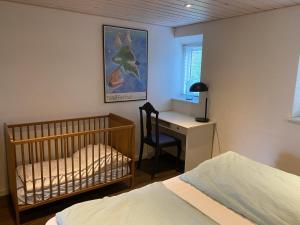 欧德尔Hegnsly的一间卧室配有婴儿床和桌椅