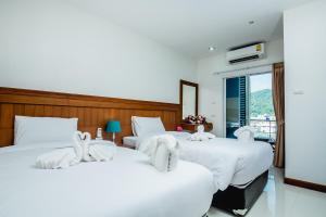 芭东海滩Aim House的两张位于酒店客房的床,配有毛巾