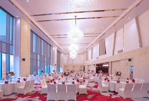 青浦上海虹桥西郊假日酒店的一个带白色桌子和白色椅子的大型宴会厅