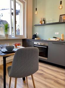 梅拉诺Galilei Apartment的厨房配有桌子、椅子、桌子和炉灶。
