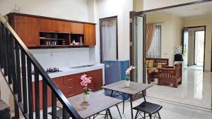 茂物Atmosfer Guest House Sentul的厨房以及带桌椅的起居室。