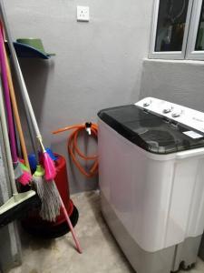 关丹HOMESTAY KUANTAN INDERA SEMPURNA 2的洗衣机,位于清洁刷旁边