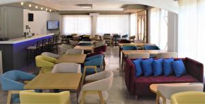 阿基欧斯尼古拉斯Apollon Hotel的餐厅设有许多桌椅和沙发