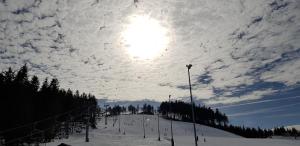 阿贝尔塔米Apartmány Plešivec的雪覆盖的滑雪场上空的云天