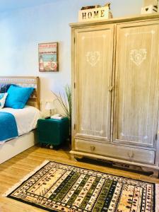 安普埃罗Cozy apartment的一间卧室配有一张床和一个大型木制橱柜