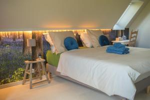 赫纲兰德B&B De Zavelaar的一间卧室配有一张带蓝色枕头的大床