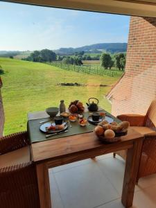 赫纲兰德B&B De Zavelaar的一张桌子,上面放着食物,享有田野的景色