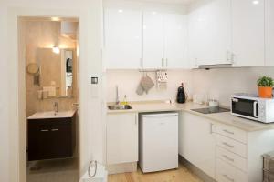 里斯本Central Studio的白色的厨房配有水槽和微波炉