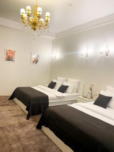 新库兹涅茨克G.S.宾馆的一间卧室配有两张床和吊灯。