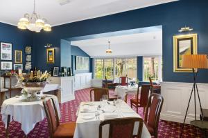 Ballingeary古迦巴拉酒店的一间配备有桌椅的用餐室和蓝色的墙壁