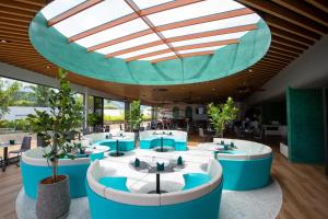 普吉镇HOMA Phuket Town的餐厅设有蓝色和白色的桌子以及玻璃天花板