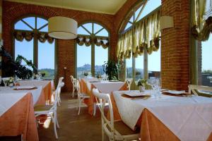 VignaleVilla Morneto的餐厅设有白色的桌椅和窗户。