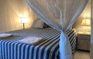 阿拉亚尔达茹达Ouro Sobre Azul Apart Hotel的一间卧室配有蓝白色床和天蓬